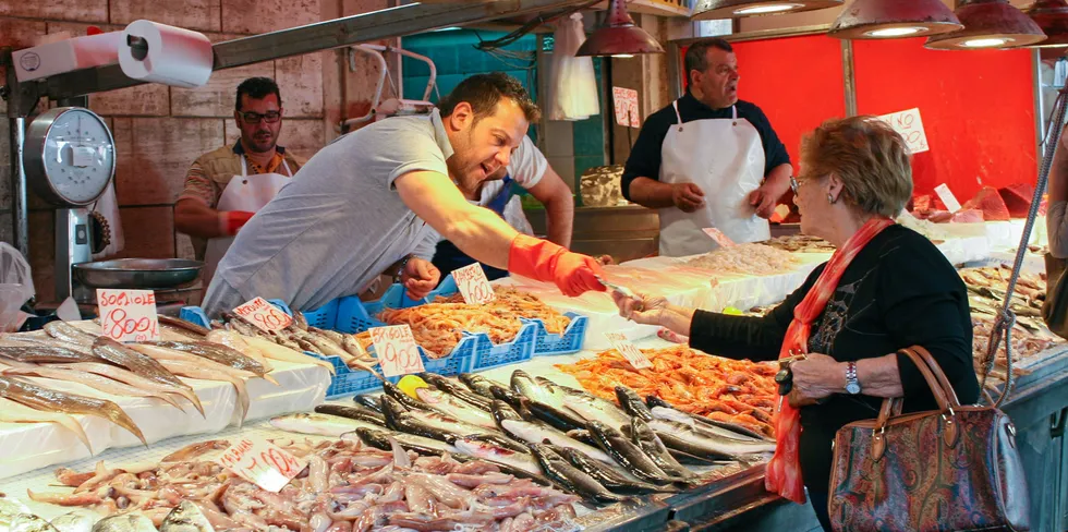Kunde kjøper sjømat på fiskemarked på Sicilia i Italia.