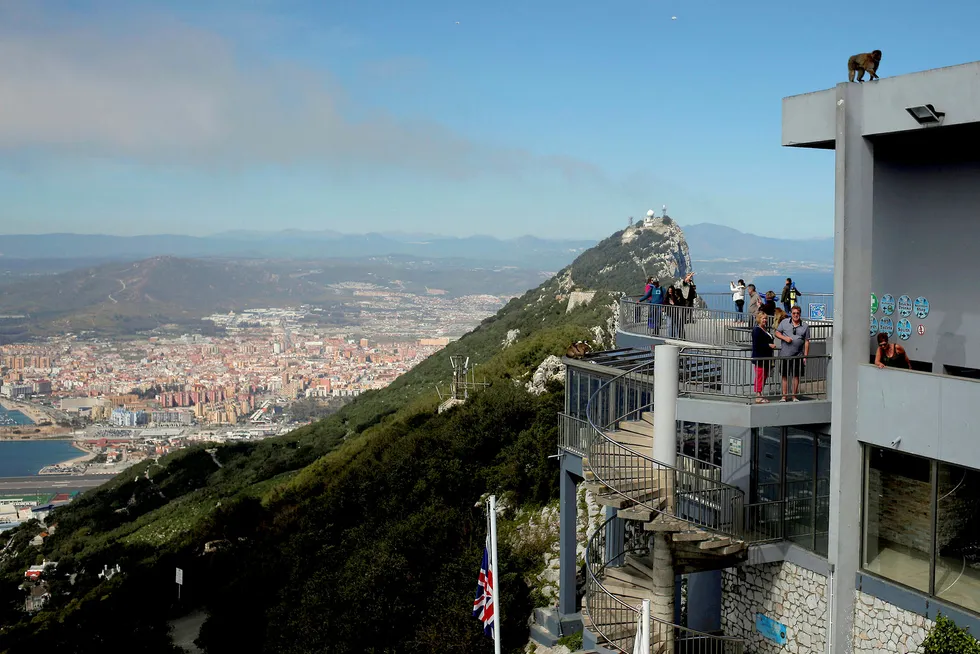 Turister står på et utsiktspunkt over klippen som utgjør landemerket i Gibraltar.