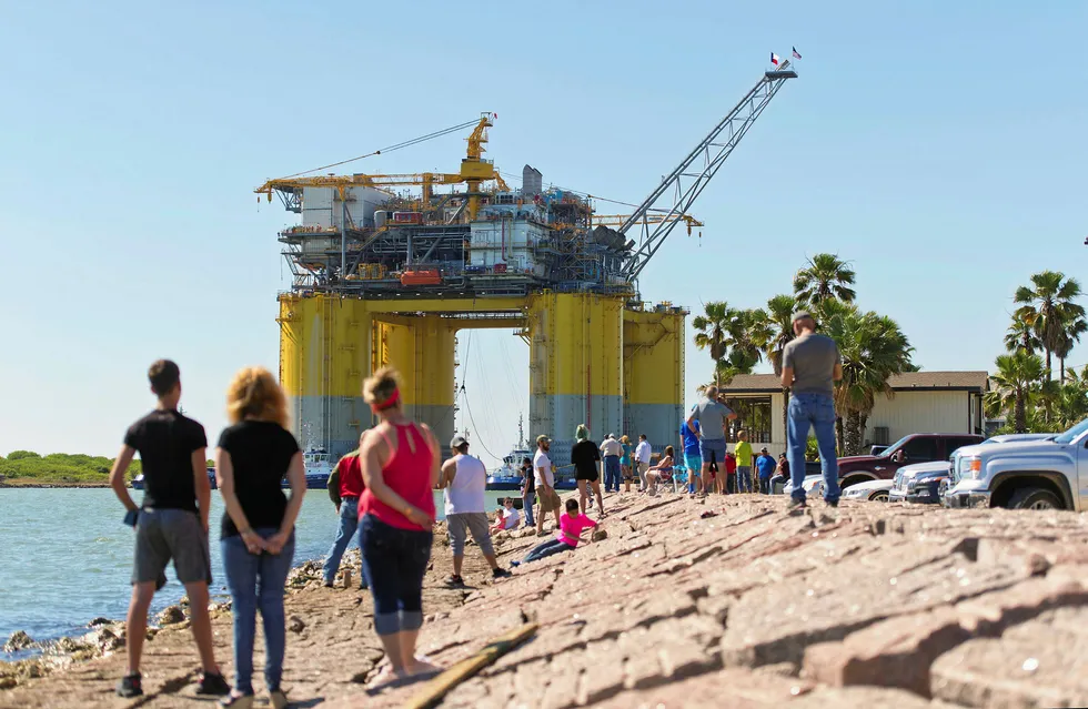 Heading out: People watch as tugs transport Hess's Stampede platform from Kiewit Offshore Services in Ingleside, Texas, to the Gulf of Mexico