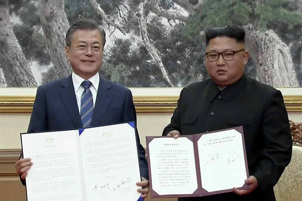 Sør-Koreas president Moon Jae-in (til venstre) og Nord-Koreas leder Kim Jong Un viser frem felleserklæringen de har signert.