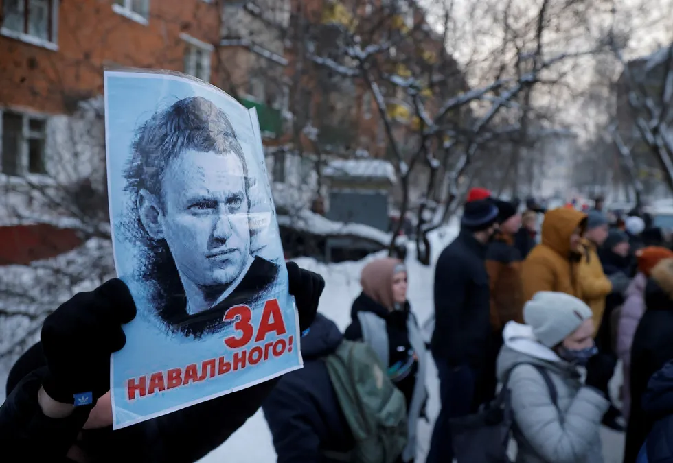 Wide support: a man holds a placard picturing Alexei Navalny as Russians gather outside a police station near Moscow where the opposition leader is being held following his detention on arrival at Sheremetyevo airport
