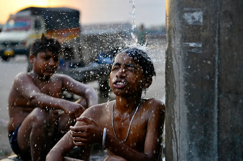 Boys bathe at a public water facility along a street on a hot summer day in Jalandhar on June 13, 2024 amid heatwave in India that's longest ever to hit the country.