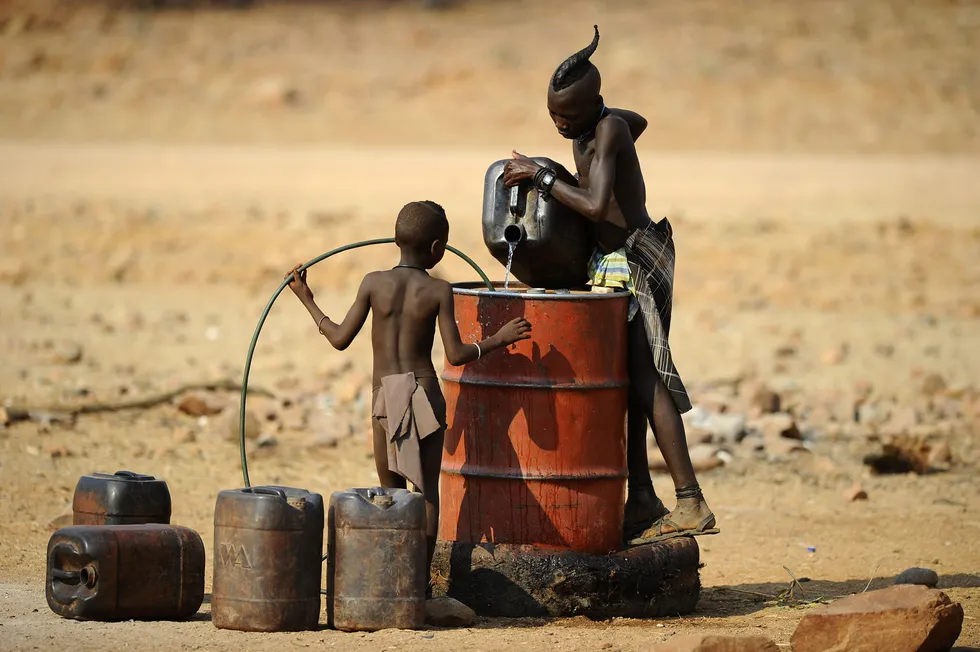 Brighter future? Two Himba boys pour water into a tank in the village of Okapare in northern Namibia