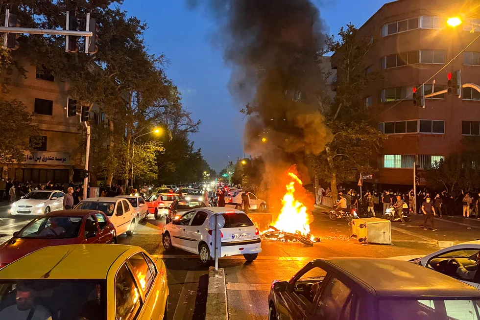 En politimotorsykkel er satt i brann i forbindelse med demonstrasjonene i Iran.