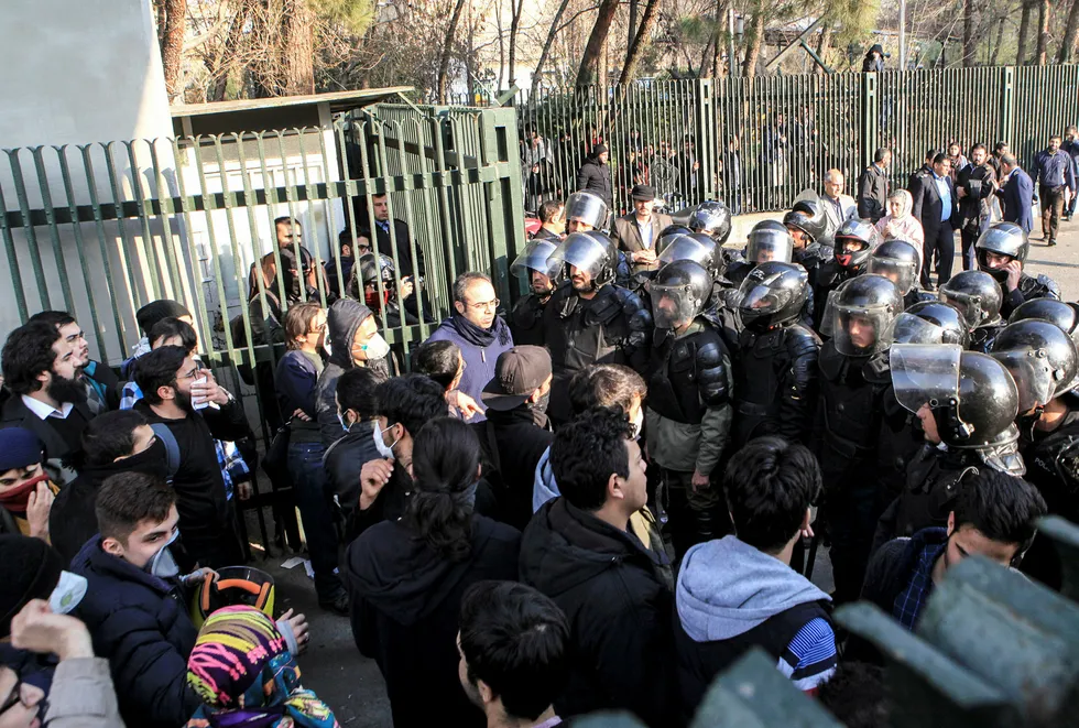 Iransk opprørspoliti hindrer her studenter å slutte seg sammen med andre under protestene der flere tusen er arrestert.