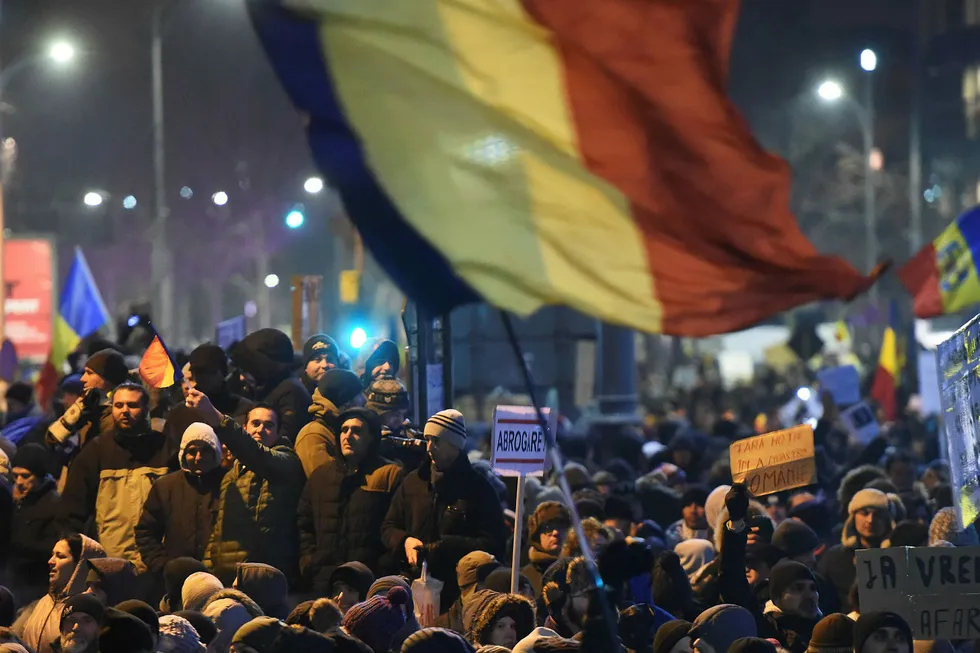 Det rumenske flagget vaier i luften under store demonstrasjoner mot Romanias nye regjeringen etter et hastevedtaks om dekriminaliserer korrupsjon. Foto: Daniel Mihailescu/Afp/NTB Scanpix