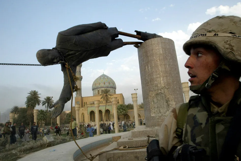 Amerikanske soldater ser på at en statue av Iraks tidligere president Saddam Hussein faller i Bagdad 9. april 2003.