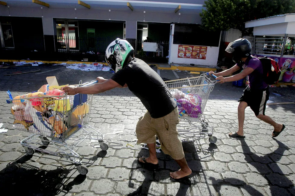 Motstand mot en pensjonreform har ført til store protester i Nicaraguas hovedstad, Managua. Bildet viser personer som har plyndret en butikk etter gateprotester. Foto: Jorge Cabrera/Reuters/NTB Scanpix