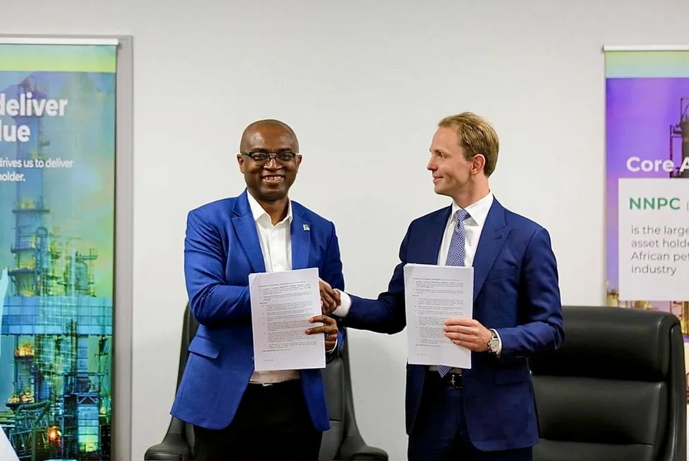 NNPC executive vice president for gas Olalekan Ogunleye(left), and Golar LNG chief executive Karl Fredrik Staubo display documents shortly after signing a deal to deploy a floating liquefied natural gas vessel in Nigeria.