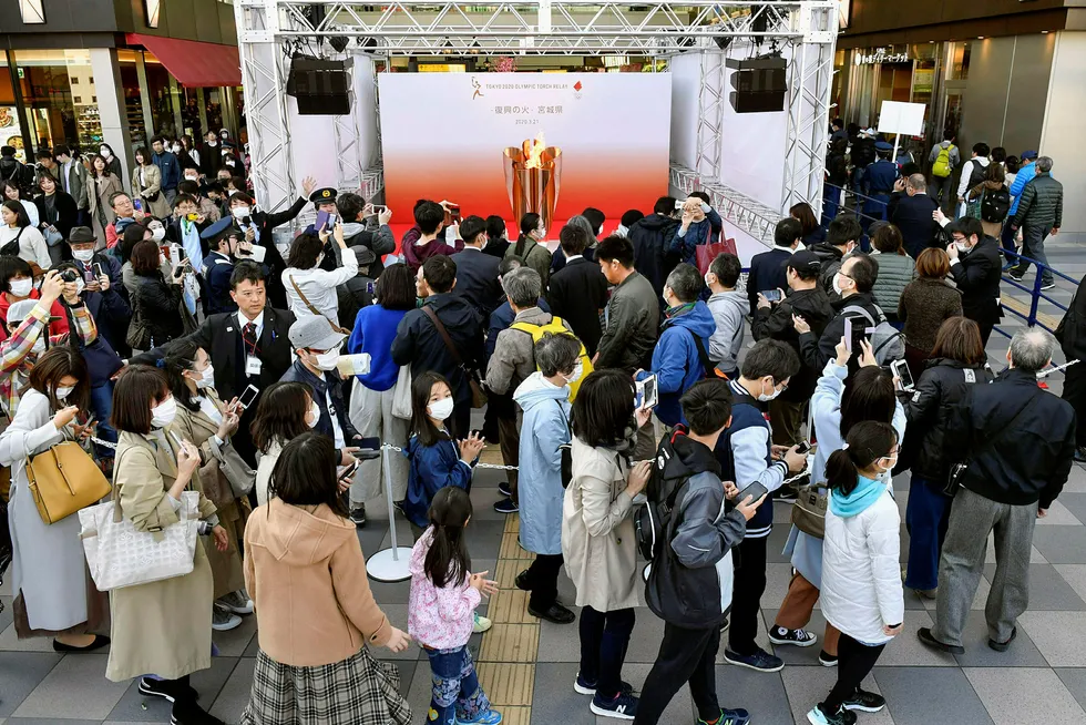 Mennesker samlet seg lørdag for å se den olympiske flammen som er kommet frem til Japan i forkant av sommerens leker i Tokyo. Mandag åpner likevel landets statsminister Shinzo Abe for at hele idrettsarrangementet må utsettes som følge av koronakrisen.