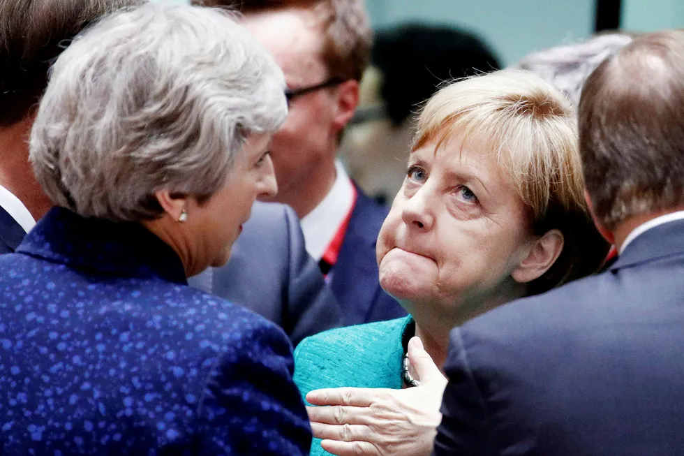 Tysklands forbundskansler Angela Merkel, her i samtale med Storbritannias statsminister Theresa May, har fått et pusterom i migrantdebatten. Fortsatt er implementeringen av EUs nye migrantenighet usikker. Foto: François Lenoir/Reuters/NTB Scanpix