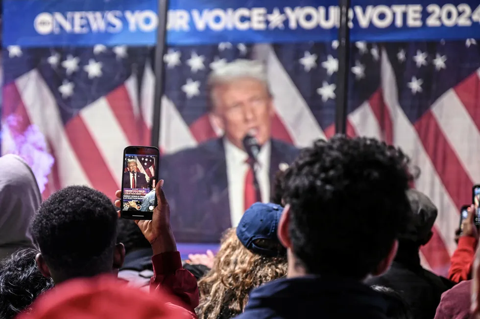 Residents in New York watch Donald Trump's speech on a screen.