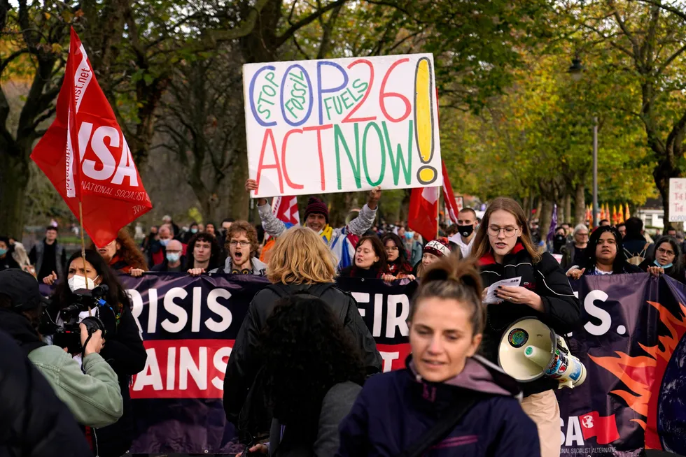 Klimaaktivister marsjerer gjennom gatene i Glasgow, Skottland, under FNs klimatoppmøte i fjor høst. Det store spørsmålet er om klimatrusselen vil lede til et globalt kollaps, skriver artikkelforfatteren.