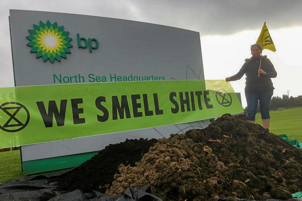 Sending a message: an Extinction Rebellion campaigner beside one of the dumped mounds of manure outside BP's Aberdeen offices