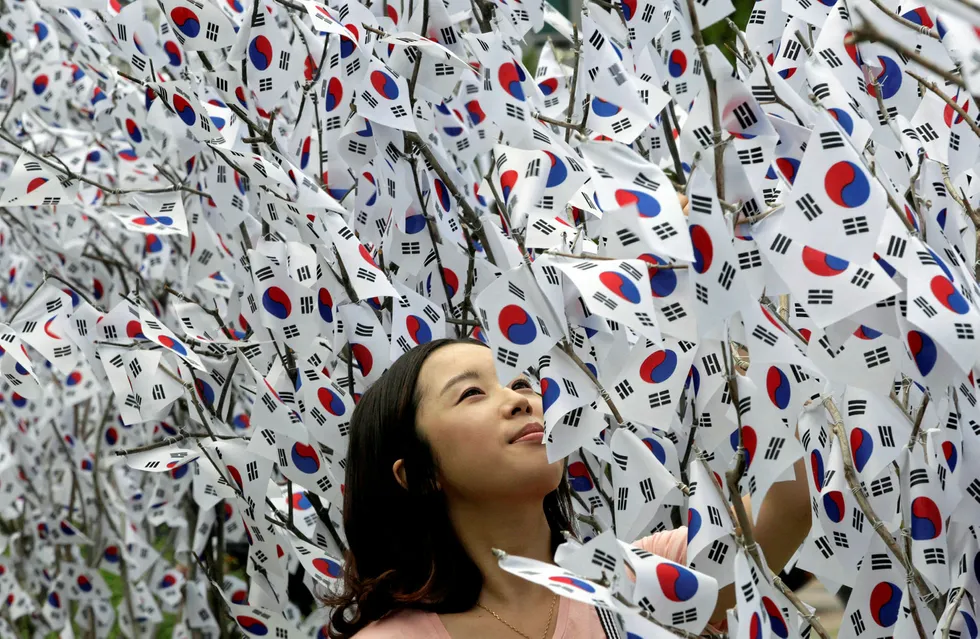 Branching out: a woman watches South Korean national flags displayed on trees