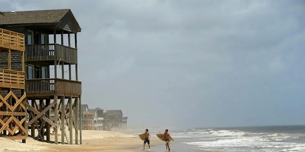 Surfers walk the beach along North Carolina's Outer Banks.