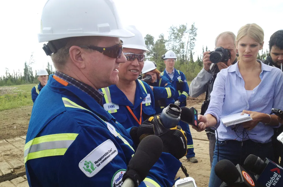 Under investigation: then-Nexen chief executive Fang Zhi (second from left) shows reporters a jar of bitumen at a spill site in Alberta, Canada, in 2015.