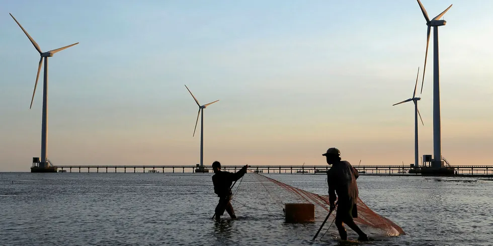 Fishermen working in front of Vietnam's first offshore wind farm, 99MW Bac Lieu