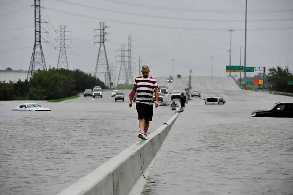 En mann måtte forlate bilen sin på en av motorveiene inn til Houston, Texas. Vannmengdene lammet store deler av storbyen mandag. Foto: Nick Oxford/Reuters/NTB Scanpix