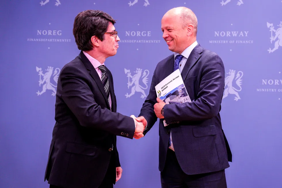 OECD-direktør Luiz de Mello overleverer OECDs toårige gjennomgåelse av norsk økonomi til finansminister Trygve Slagsvold Vedum (Sp) i Oslo torsdag.