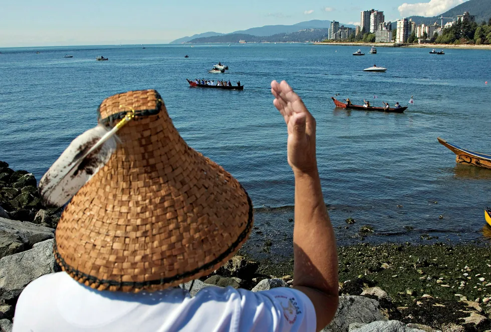 In the spotlight: a Squamish elder waves at first nation canoes in Vancouver, British Columbia