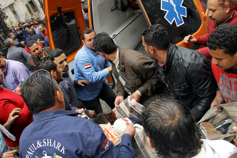 En skadet person bæres ombord i en ambulanse etter en bombe gikk i luften i nærheten av en kirke i den egyptiske byen Alexandria. Foto: Stringer/AFP