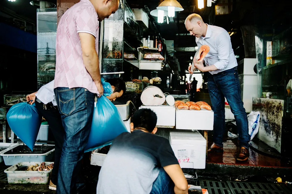 Sigmund Bjørgo hos Norges sjømatråd, som her sjekker en laks på det lokale fiskemarkedet i Shanghai, tror på 20-dobling av eksporten fra Norge. Foto: Fartein Rudjord
