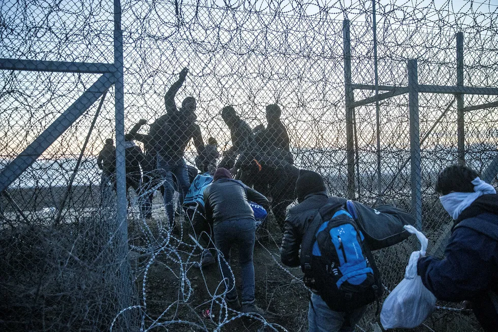 En gruppe flyktninger prøver å ta seg inn i Hellas gjennom et grensegjerde i Erdine i Tyrkia.