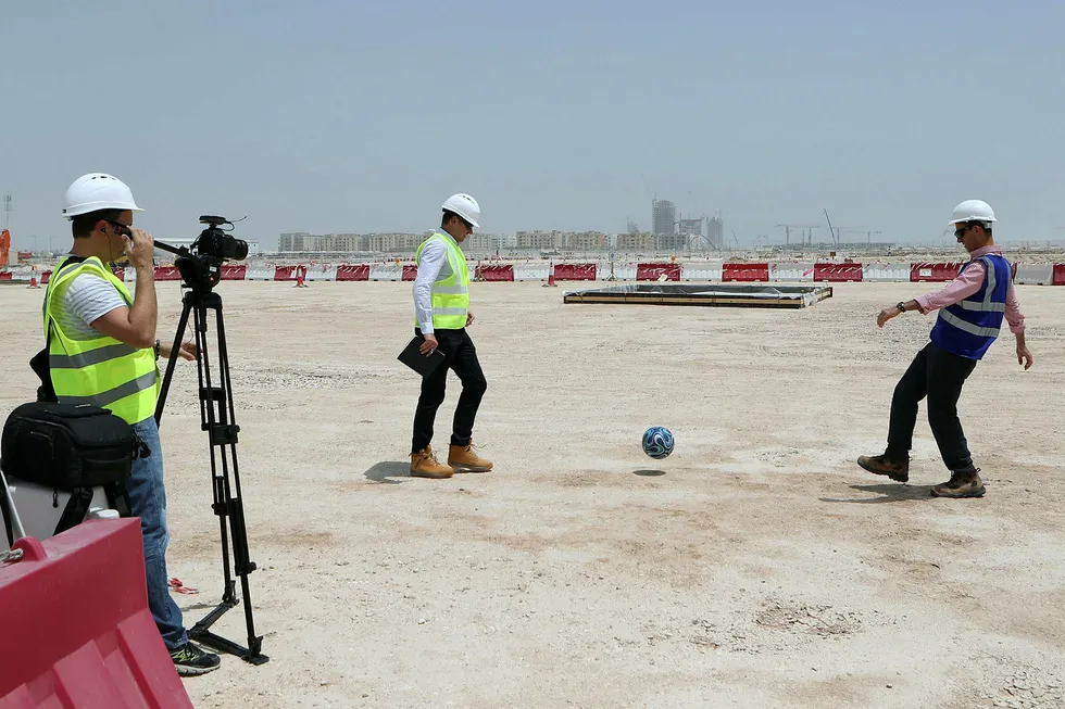 Byggeleder Tamim Loutfi Elabed (til høyre) sparker en fotball på grunnen hvor Lusail-stadionet med 80.000 seter skal bygges i anledning fotball-VM i Qatar i 2022. Landet har fått mye kritikk for vilkårene som tilbys fremmedarbeiderne på byggeplassene. Foto: Karim Jaafar/AFP/NTB Scanpix