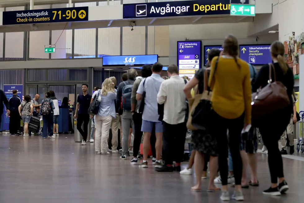 Passasjerer på Arlanda utenfor Stockholm i kø foran SAS-skranken under streiken i sommer.