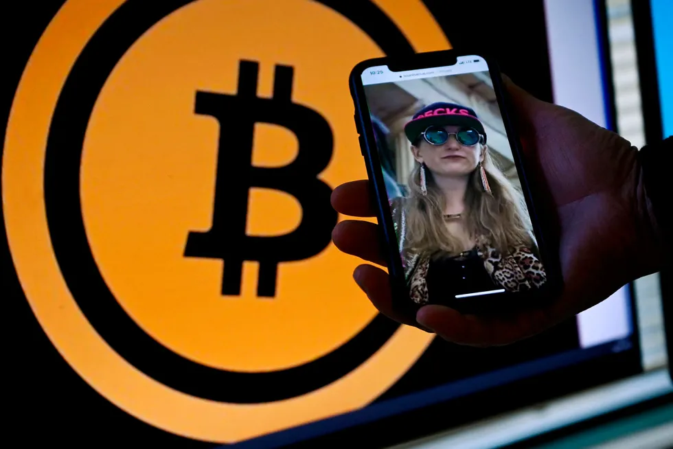 Heather Morgan, pictured on a phone in front of the bitcoin logo, was arrested and charged with attempting to launder more than $3.6bn in stolen bitcoin with her husband, Ilya Lichtenstein.