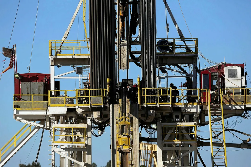 Rigged up: workers stand on the platform of a rig in the Permian basin