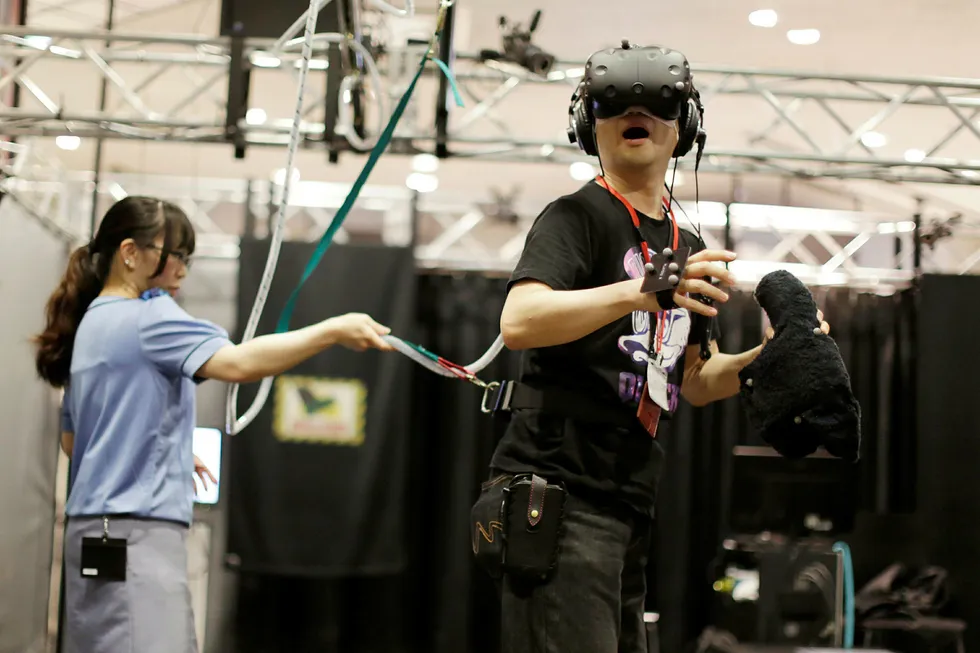 Arkivbilde. En gjest får prøve VR-løsningen HTC Vive under en demonstrasjon. Foto: NTB Scanpix/AP Photo/Eugene Hoshiko