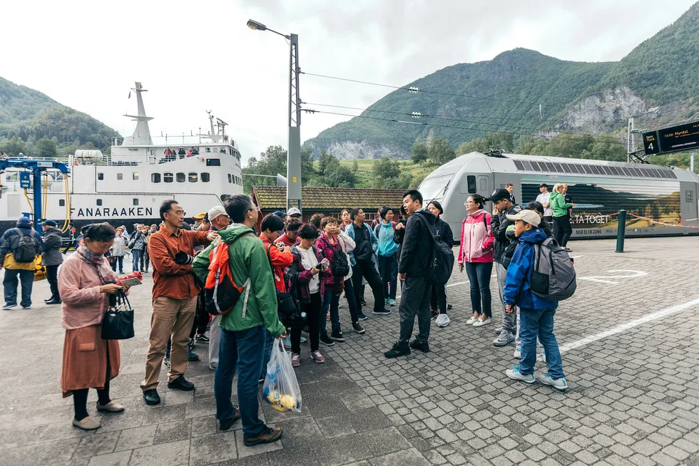 Den kraftige turistveksten fra Kina avtok i juni, viser tall fra SSB. Her er en gruppe kinesiske turister vei til toget i Flåm. Foto: Johannes Worsøe Berg