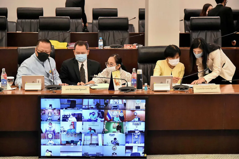 In the room: Thai government senior officials wearing protective face masks attend a teleconference for a weekly Cabinet meeting in Bangkok this week