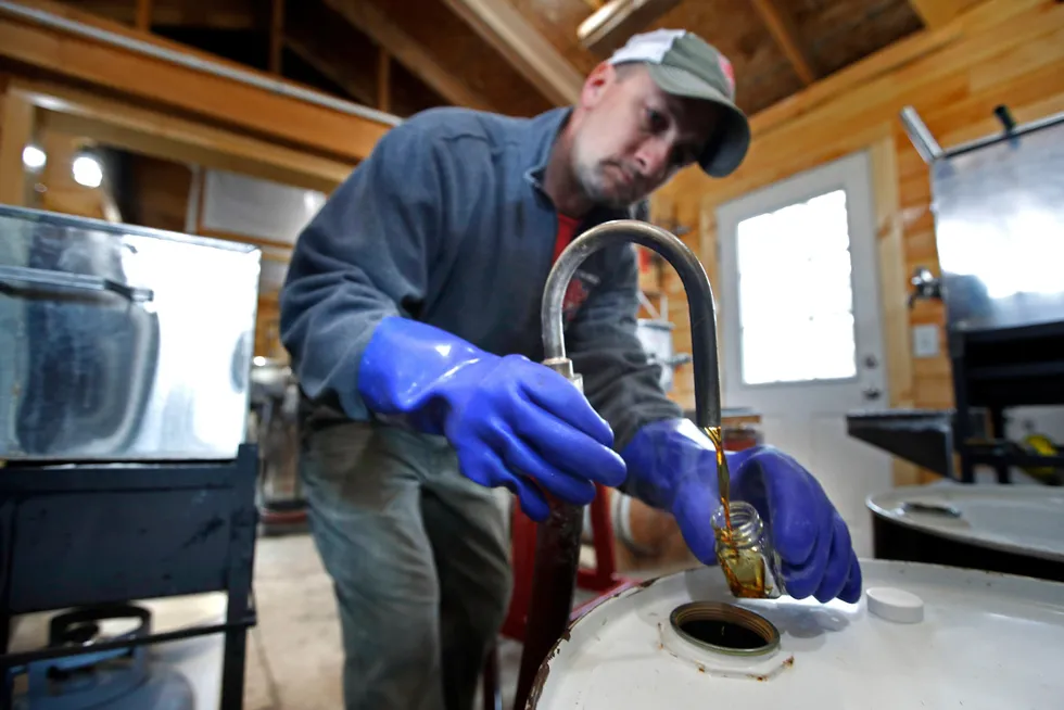 Supply shortage: a worker fills a sample bottle of maple syrup