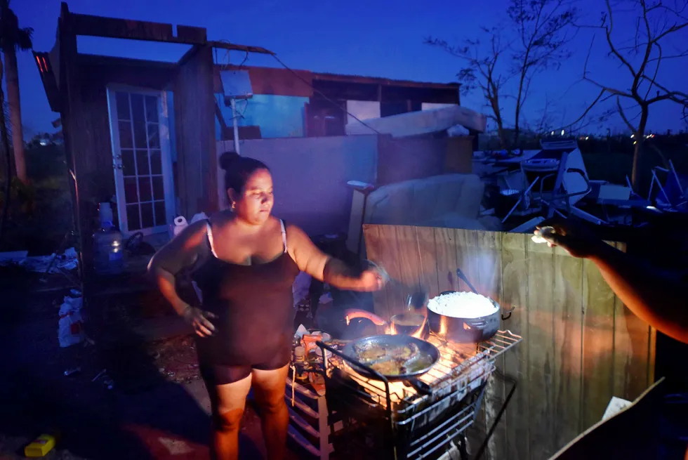 Kvinnen Maria tilbereder mat rett ved hjemmet sitt som ble ødelagt av orkanen «Maria» i Toa Alta, Puerto Rico, 25. september. Området mangler elektrisitet og sliter med å grave ut og rydde opp etter orkanens herjinger, som har ført til minst 33 dødsfall i Karibien. Foto: Hector Retamal/AFP/NTB Scanpix