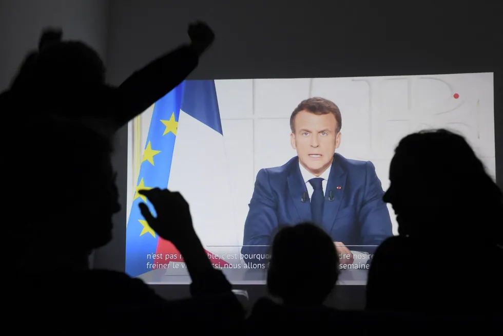 Lockdown: People listen to French President Emmanuel Macron order a Covid-19 lockdown during a televised address