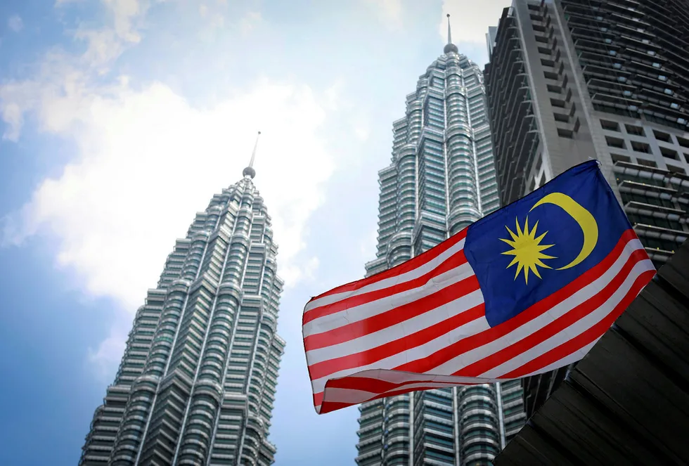 Malaysia's national flag flies in front of its landmark Petronas Twin Towers in Kuala Lumpur