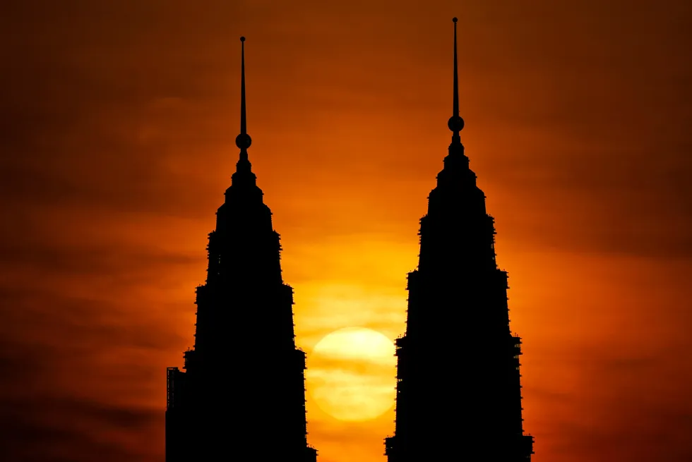 The sun rises behind Petronas Twin Towers - Petronas' headquarters - in Kuala Lumpur, Malaysia.