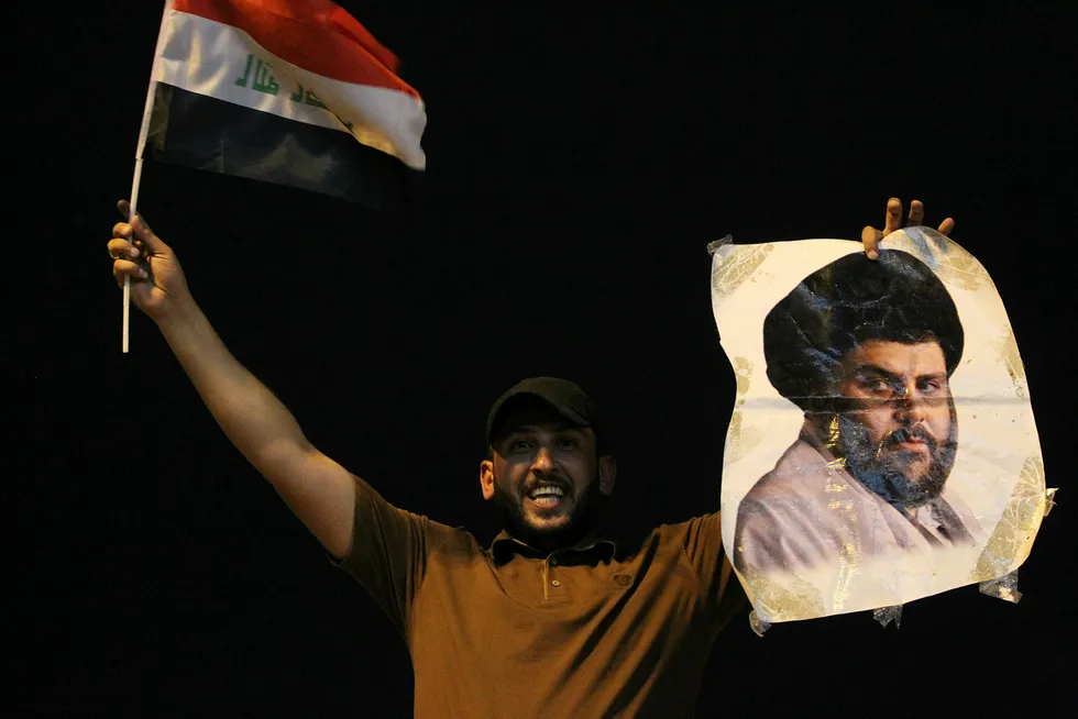 En irakisk mann med bilde av sjialederen Moqtada al-Sadr gleder seg over valgresultatene. Foto: Ahmad Al-Rubaye/AFP photo/NTB Scanpix
