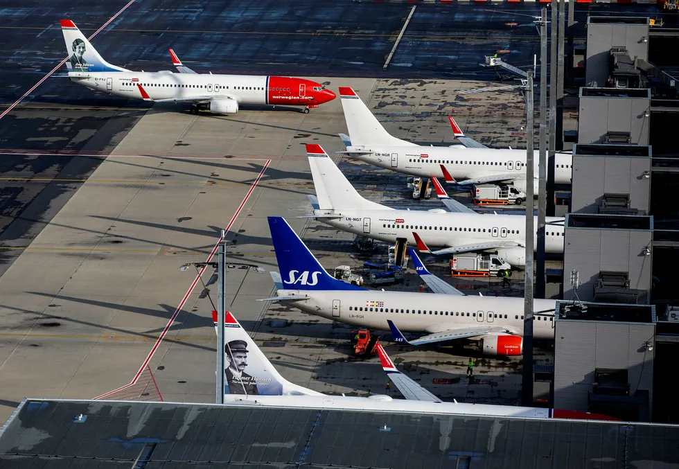 Flybransjen ber om nødkutt i flyavgiftene. Her Norwegian- og SAS-fly på Oslo lufthavn.