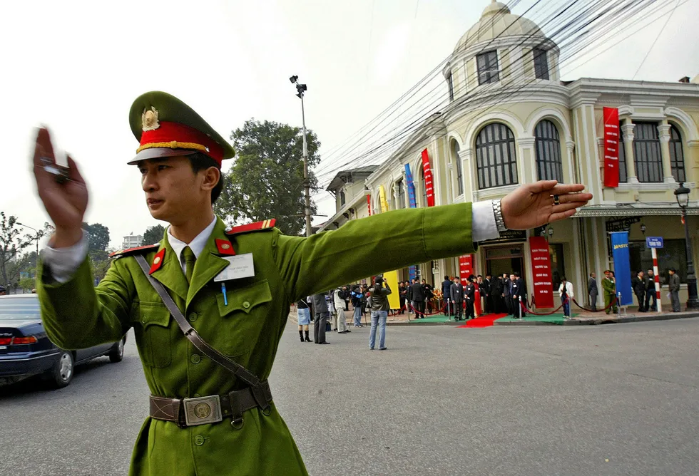 A policeman directs traffic in front of the building housing the Hanoi Stock Market in 2005