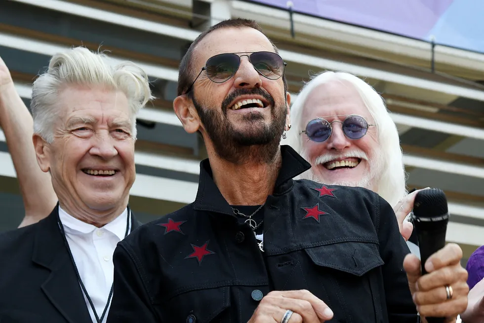 Tidligere Beatles-medlem Ringo Starr slås til ridder av dronning Elizabeth. Her er han avbildet sammen med filmskaper David Lynch (t.v.) og musiker Edgar Winter (t.h) i forbindelse med hans 77-årsdag i juli. Foto: Chris Pizzello / AP / NTB scanpix
