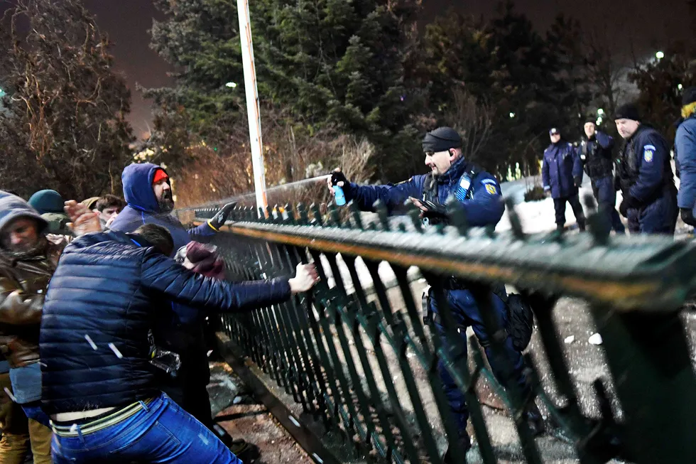 Protestbølgen er den største siden diktatoren Nicolae Ceausescus fall i 1989. Her bruker en politimann pepperspray mot demonstranter i Bucuresti. Foto: DANIEL MIHAILESCU/AFP/NTB scanpix