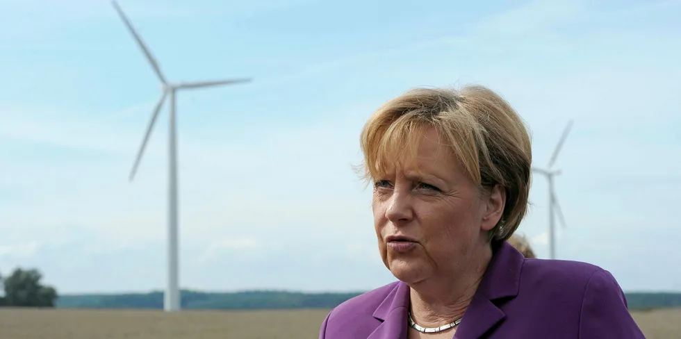 German Chancellor Angela Merkel stands next to wind turbines near the northern German city of Rostock.
