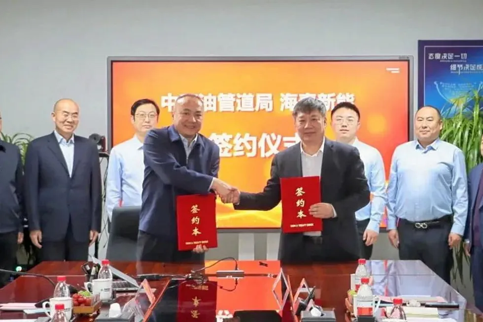 Executives from Tangshan Haitai New Energy Technology and China Petroleum Pipeline Engineering Corporation shaking hands on their pipeline deal.