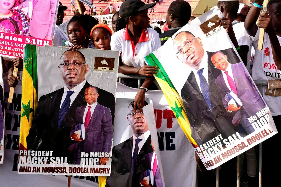 Victorious: supporters in Dakar hold posters of Senegalese President Macky Sall