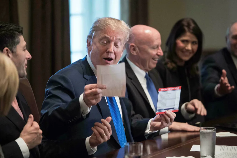 USAs president Donald Trump virker fornøyd der han sammen med republikanere fra kongressen titter på at eksemplar med liste over foreslåtte skattekutt. Foto: Nicolas Kamm/AFP photo/NTB scanpix