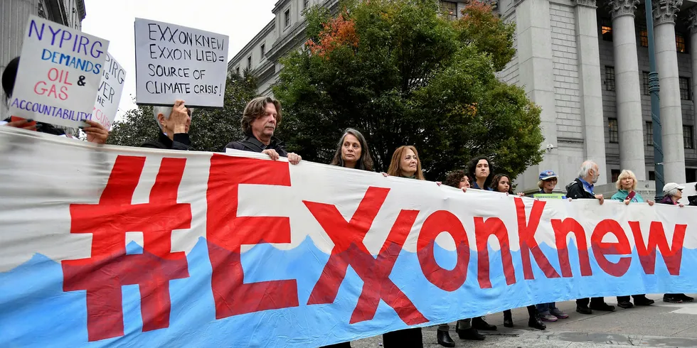 Climate activists protest on the first day of the ExxonMobil trial for misleading shareholders about their global warming knowledge, outside the New York State Supreme Court building in New York City on 22 October.